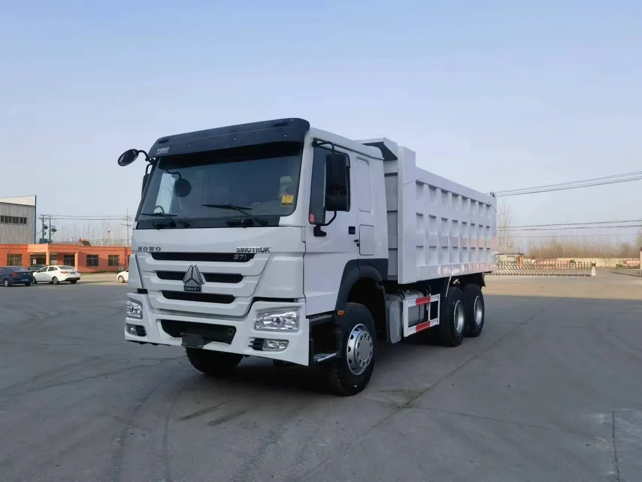 HOWO 6x4 dump truck side view, yellow cab, steel tipper body raised