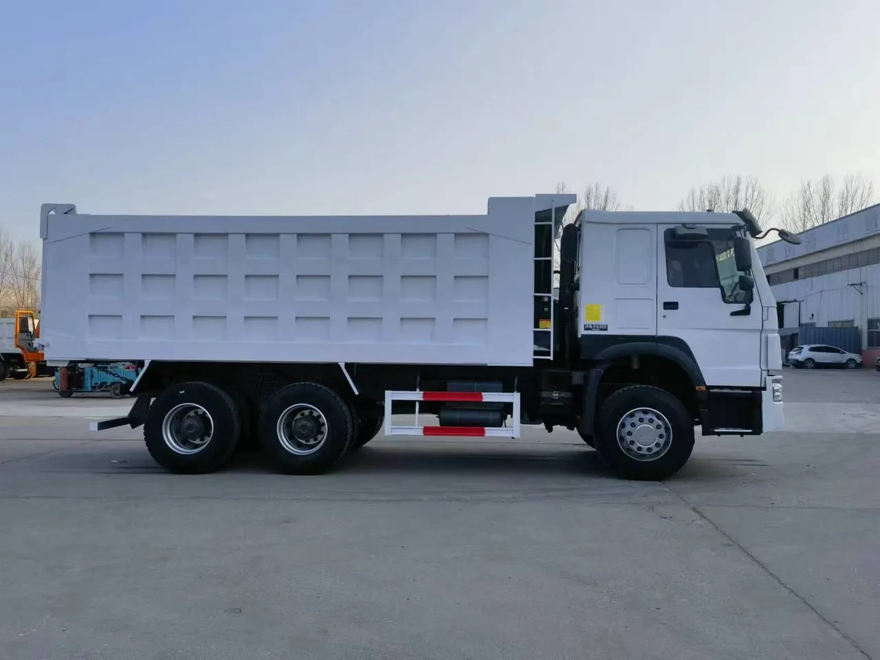 SHACMAN 6x4 dump truck on quarry haul road, red cab, tipper body loaded