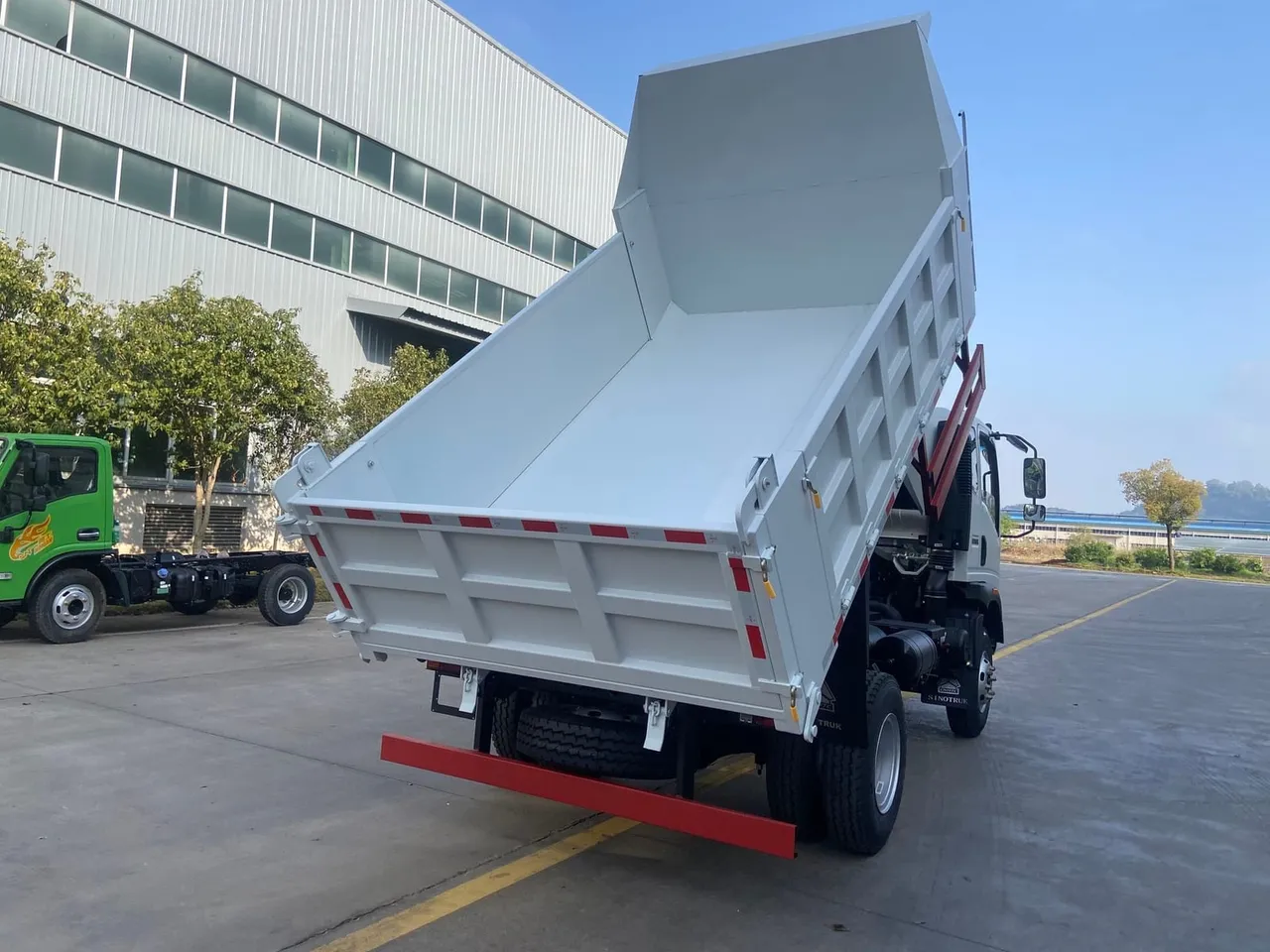 HOWO 4x2 light-duty dump truck with raised tipper body on inspection yard