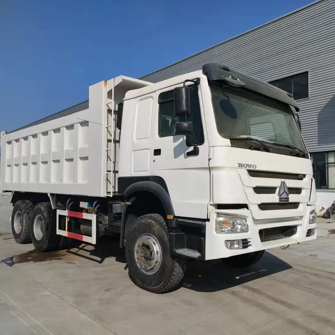 Row of inspected used HOWO and SHACMAN heavy trucks ready for export at Sigma Truck yard