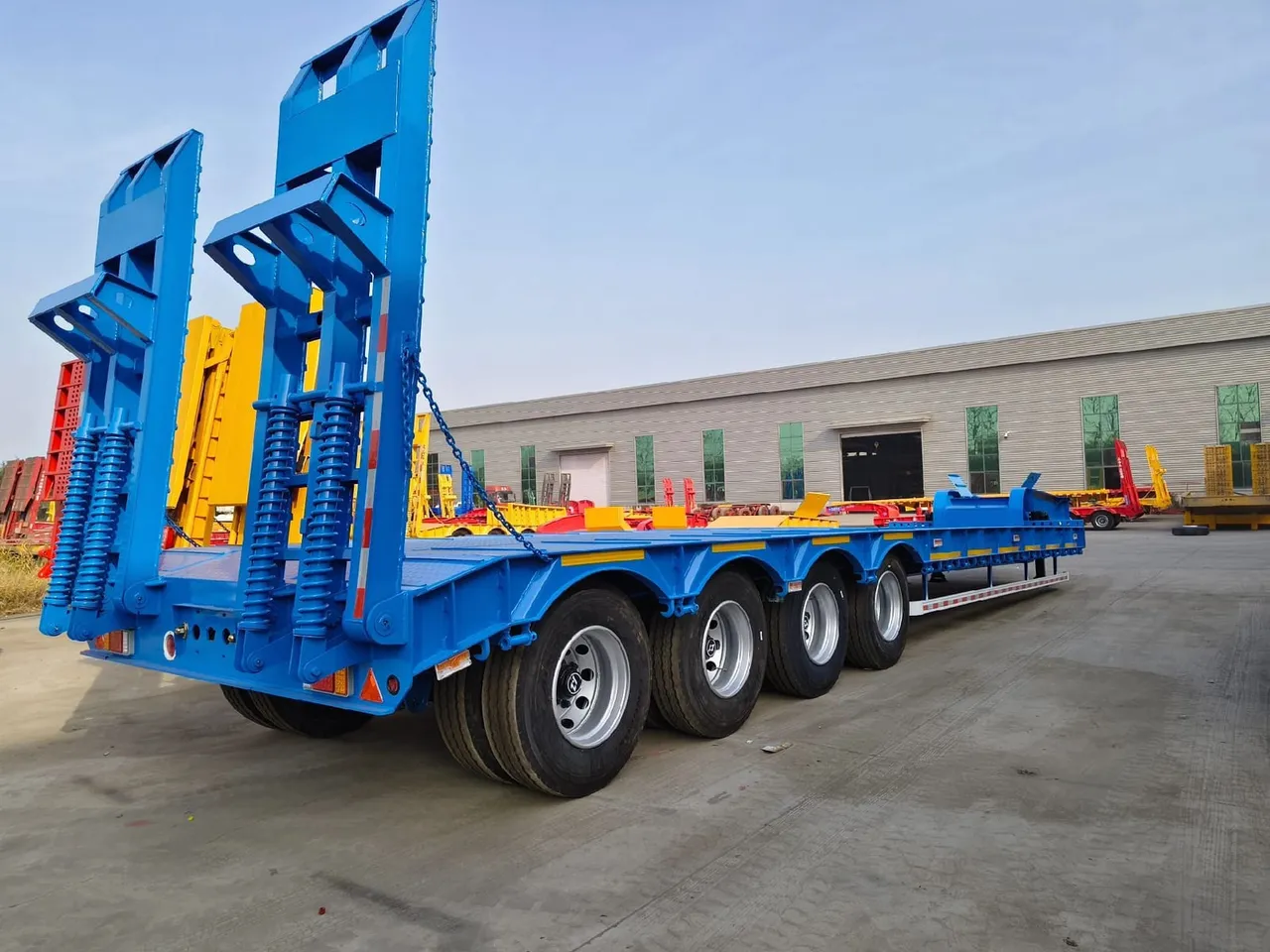 Used 3-axle low bed trailer with hydraulic ramps ready for export, paired with heavy 6x4 tractor head