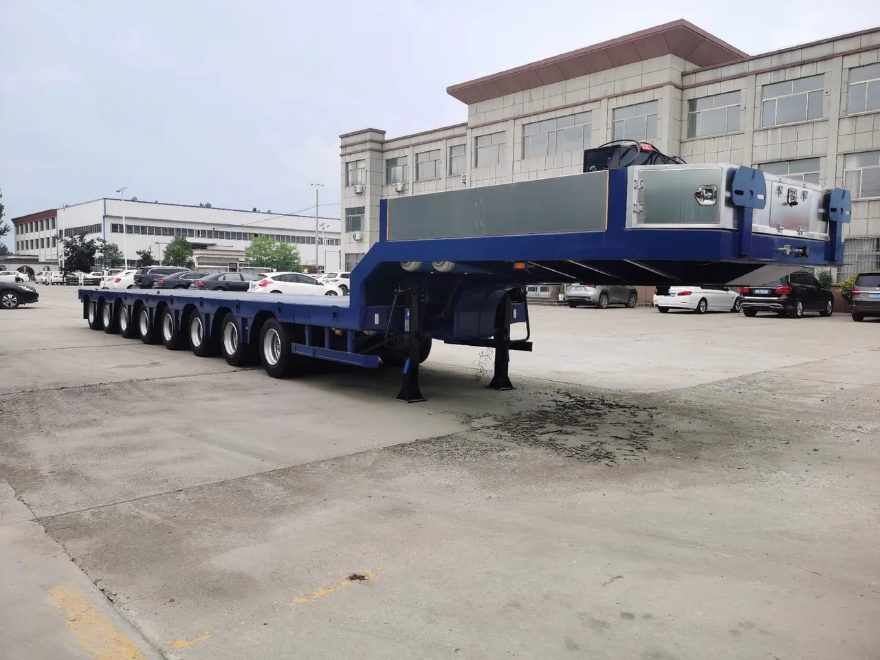Used 3-axle lowbed semi-trailer with folding ramps, ready for export